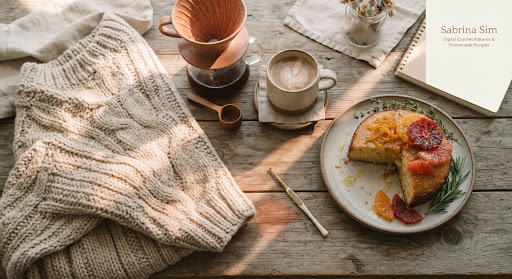 Cream crochet, yarn, wooden hooks, and a warm drink on a rustic table